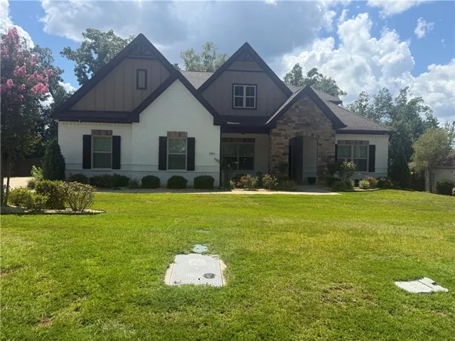 A distinguished residence featuring a blend of white brick and stone accents under a gabled roof.