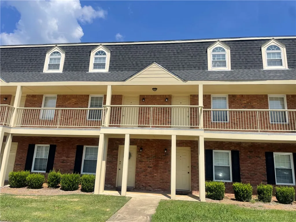 Classic brick exterior showcases architectural dormer windows and welcoming private entryways.