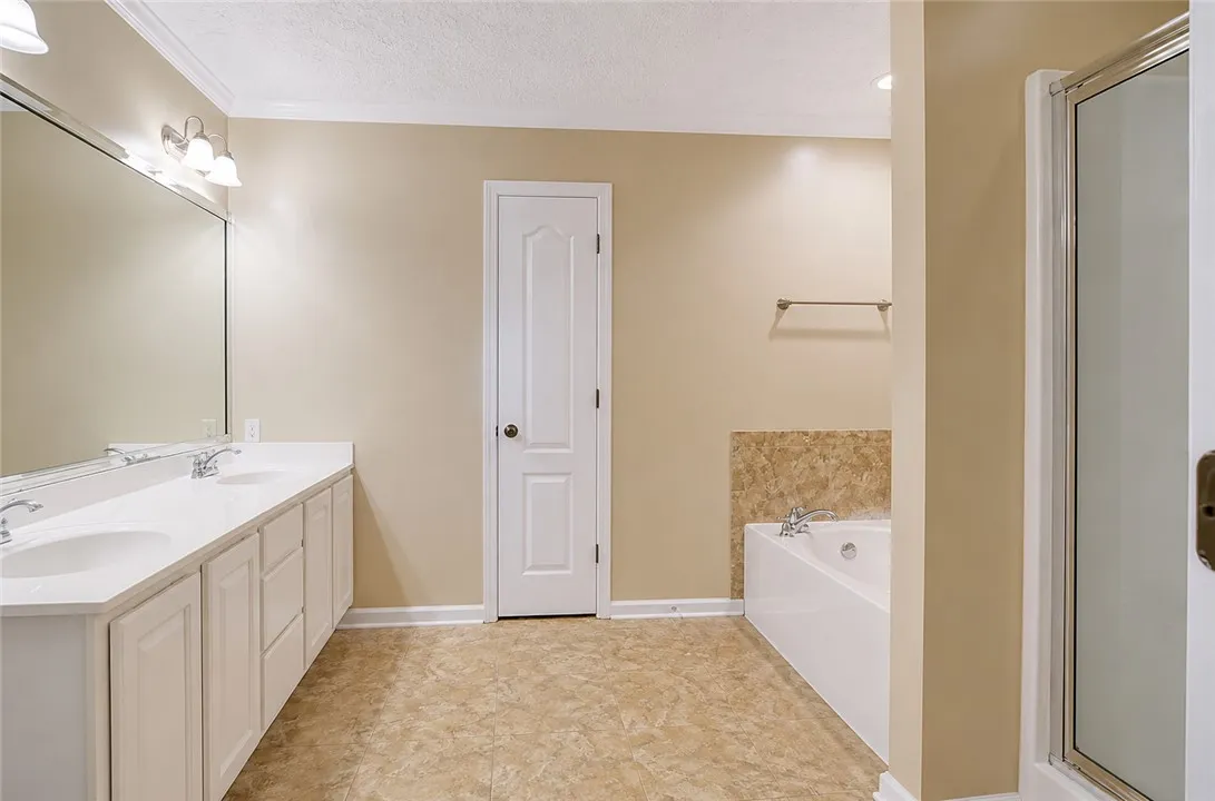 Well-appointed bathroom offering dual vanities, a separate shower, and a spacious soaking tub.