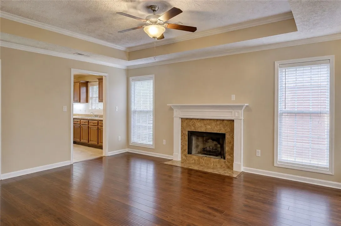 Hardwood floors complement the inviting fireplace in this well-appointed living area.