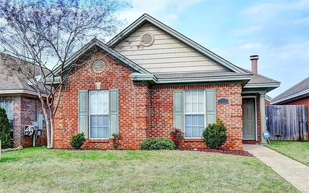 A classic brick exterior with well-maintained landscaping presents a welcoming first impression.
