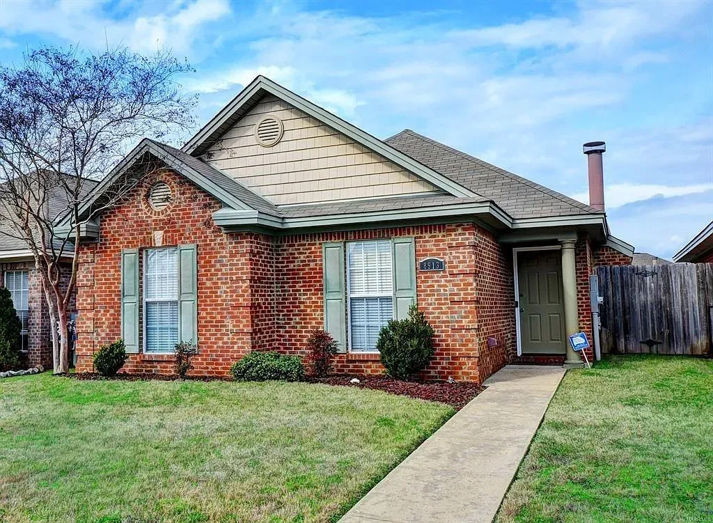 A classic brick exterior with inviting shutters and a well-maintained lawn welcomes you home.
