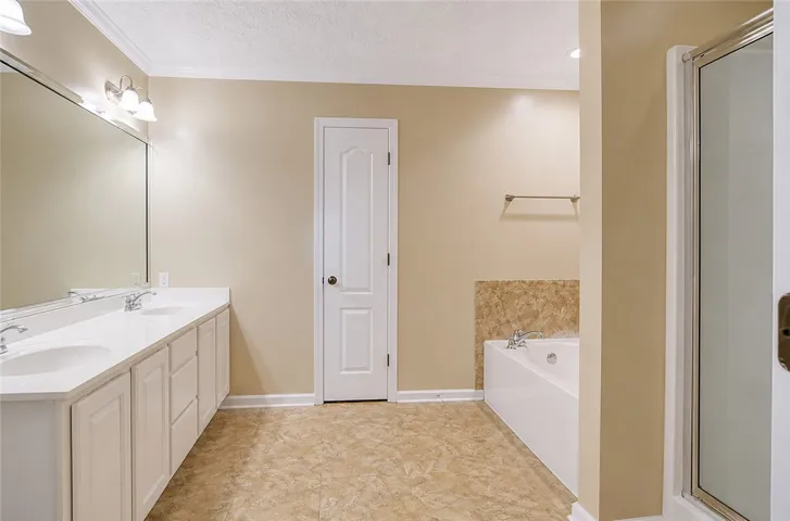 Well-appointed bathroom offering dual vanities, a separate shower, and a spacious soaking tub.