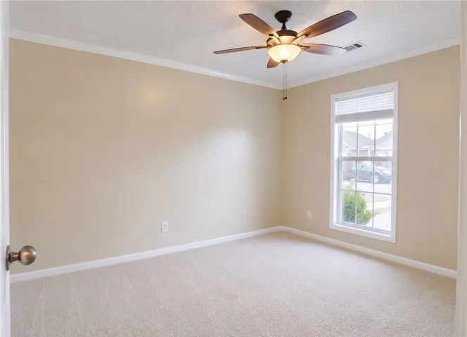 A well-proportioned bedroom with a large window and overhead fan provides a tranquil retreat.