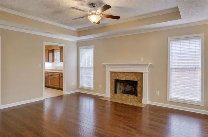 Hardwood floors complement the inviting fireplace in this well-appointed living area.