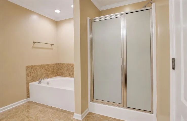 Indulge in relaxation with this inviting soaking tub and sleek glass-enclosed shower.
