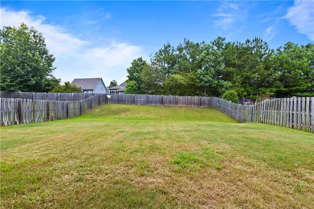 A generously sized backyard, securely enclosed by a privacy fence, ready for outdoor enjoyment.
