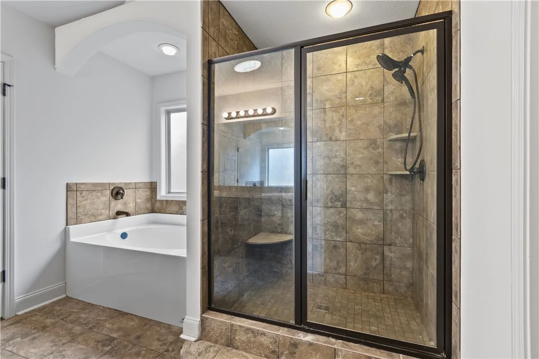 Soaking tub and tiled walk-in shower.
