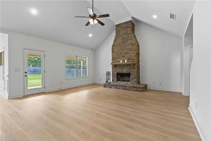 A spacious great room a very tall vaulted ceiling and an impressive stone fireplace.