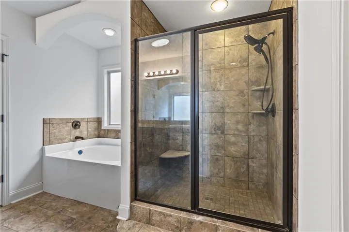 Soaking tub and tiled walk-in shower.