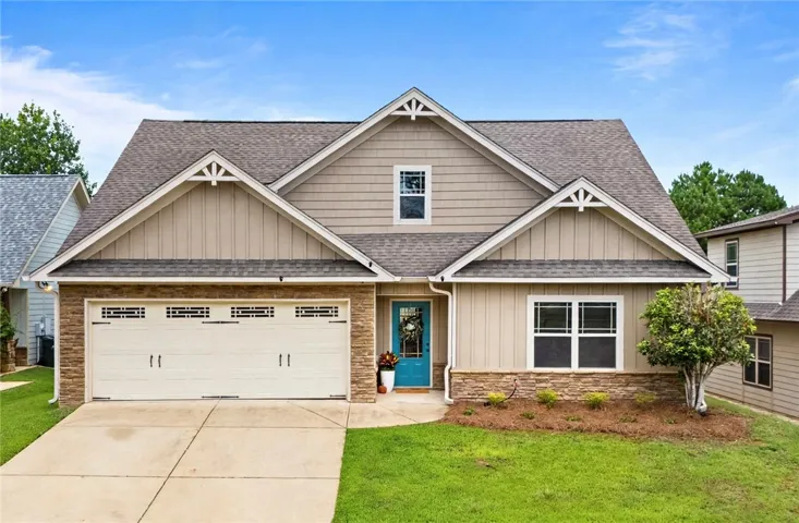 Craftsman styling shines through gabled rooflines, shake accents, and stone details on this inviting exterior.