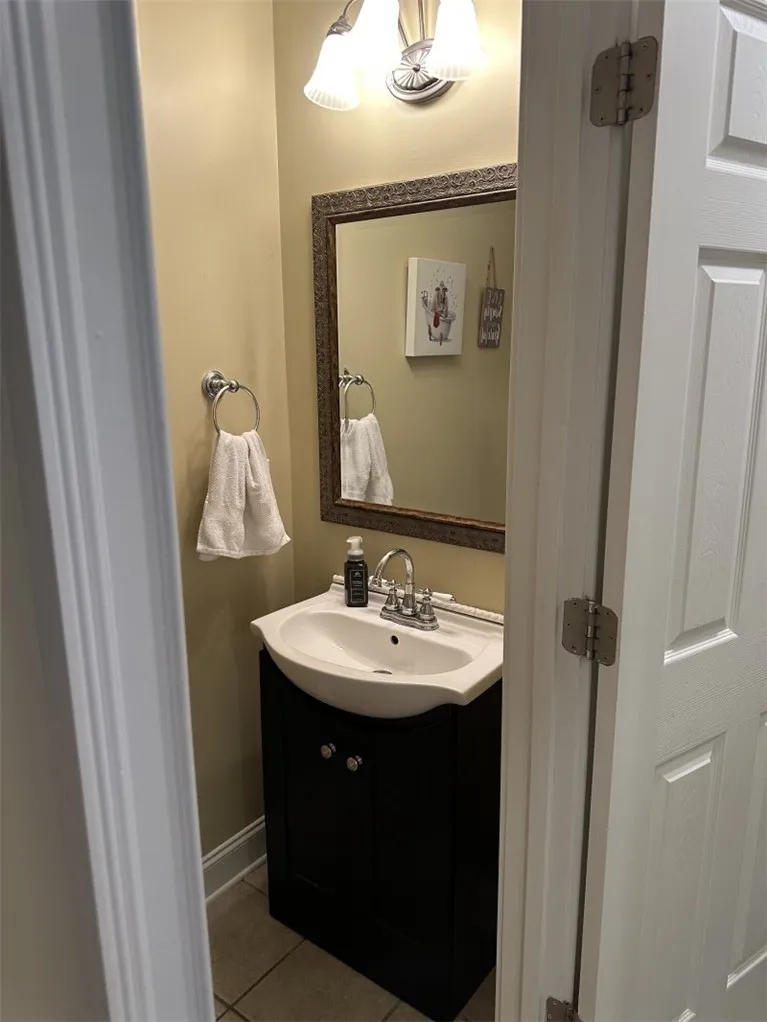 A compact vanity with classic fixtures anchors this functional powder room space.