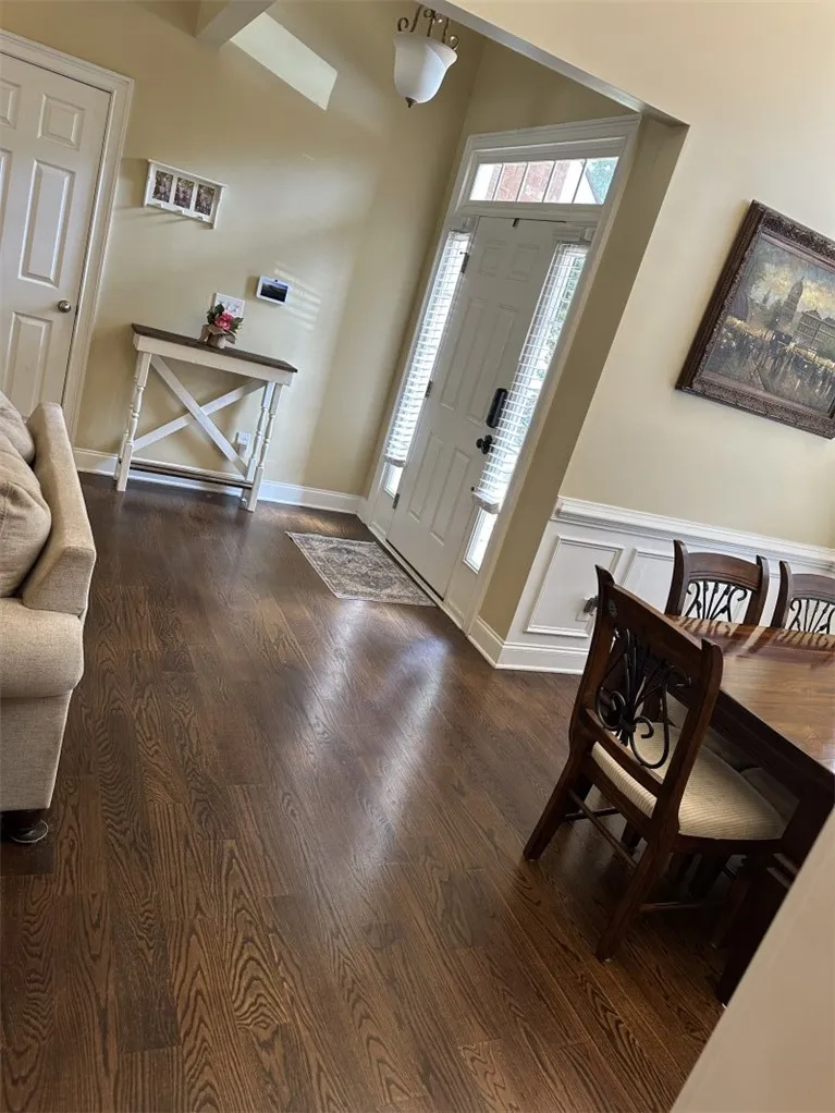 Rich hardwood floors sweep through an inviting entryway detailed with classic wainscoting.