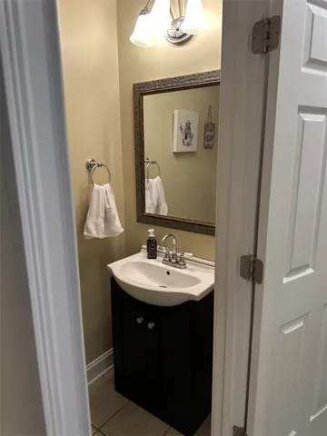 A compact vanity with classic fixtures anchors this functional powder room space.