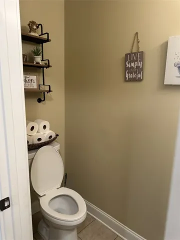 Tiled flooring and warm neutral walls define this functional powder room space.