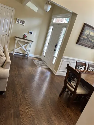 Rich hardwood floors sweep through an inviting entryway detailed with classic wainscoting.