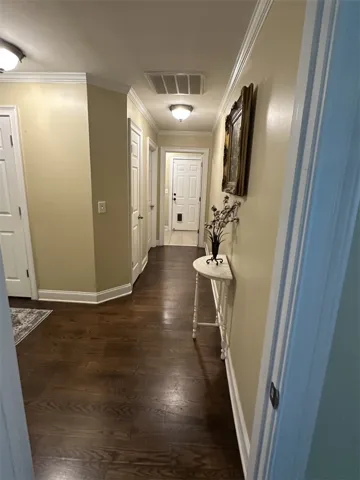 Warm hardwood flooring and classic crown molding guide you through this inviting hallway.