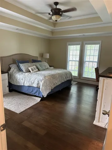 Rich hardwood floors and a tiered tray ceiling define this elegant private retreat.