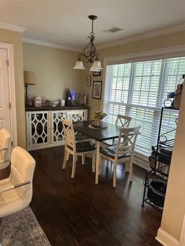 Gleaming hardwood floors and classic crown molding anchor this inviting casual dining area.