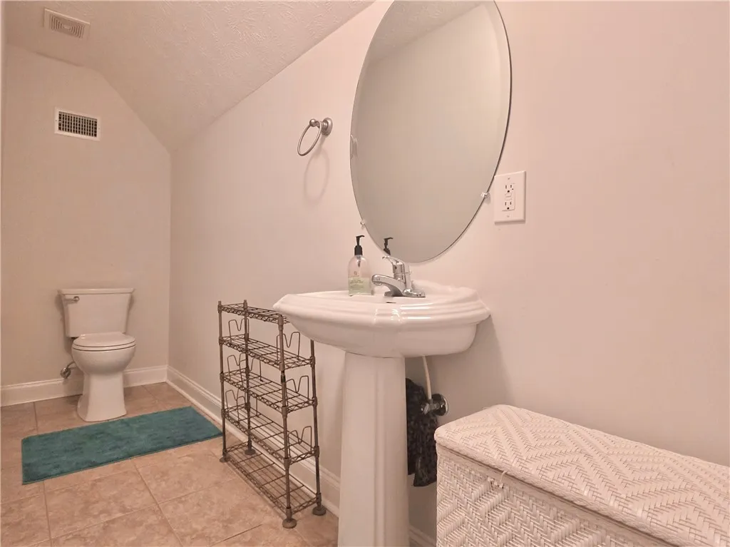 Sloped ceilings and neutral tile flooring define this functional powder room setup.
