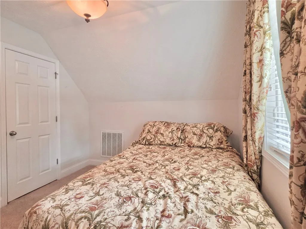 Slanted ceilings create a cozy and intimate atmosphere in this charming top-floor bedroom.