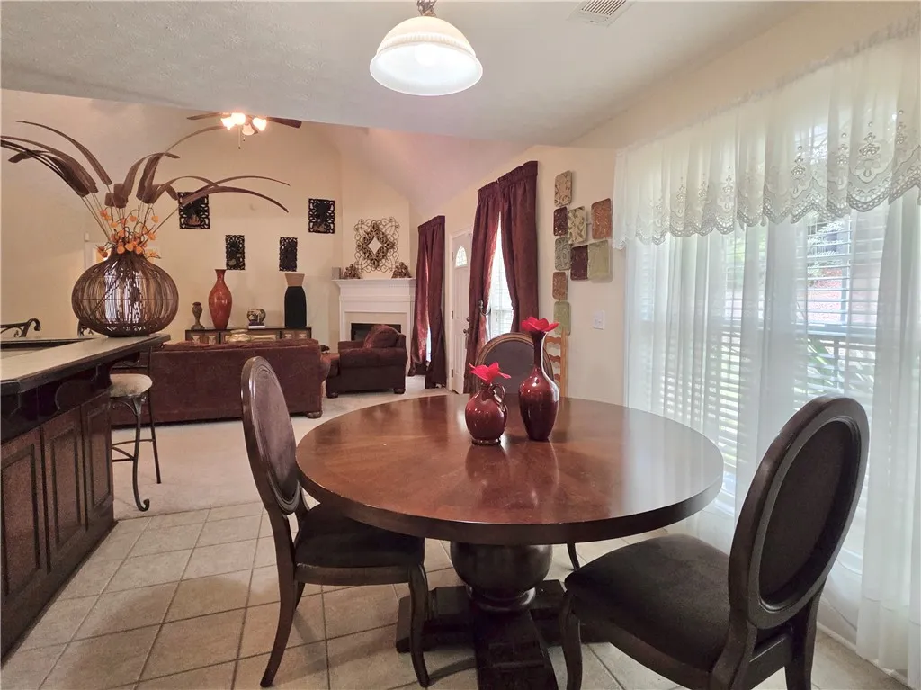 An inviting eating area transitions smoothly into the carpeted living space beyond.
