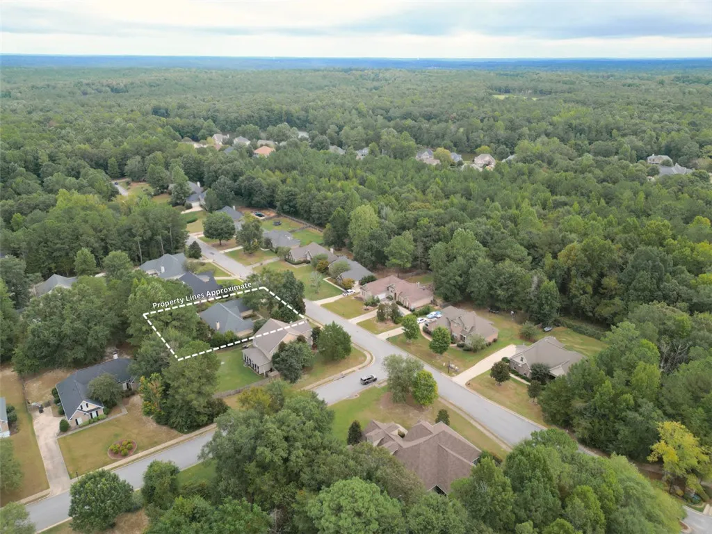 An aerial perspective showcases a spacious lot nestled in a quiet, tree-lined neighborhood.