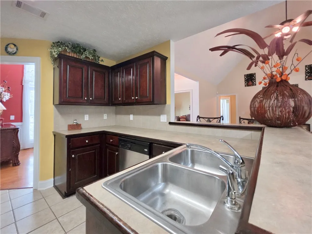 Rich dark wood cabinetry pairs with durable tile flooring in this functional kitchen layout.