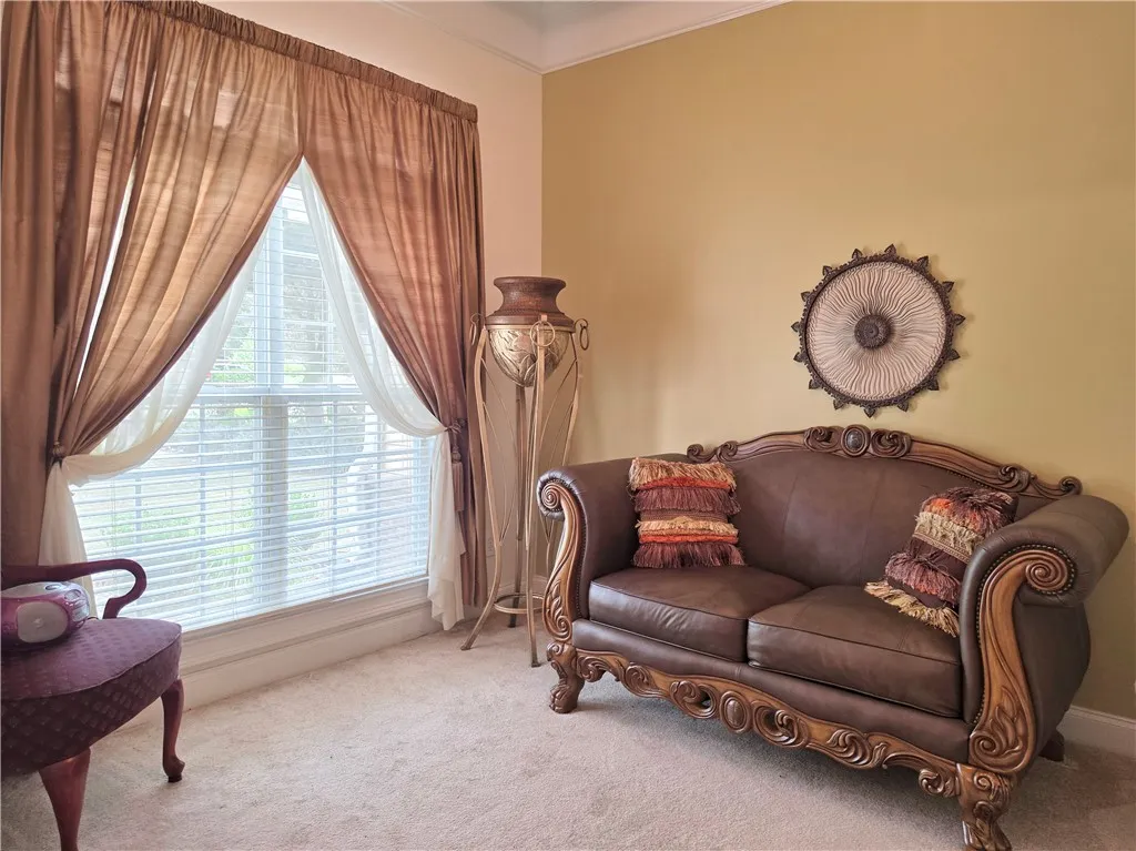 High ceilings and a large window bring architectural charm to this comfortable seating area.