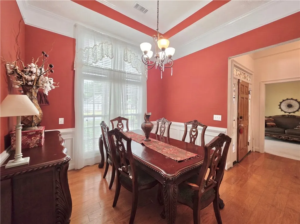 Elegant crown molding complements warm hardwood flooring in this formal dining area.