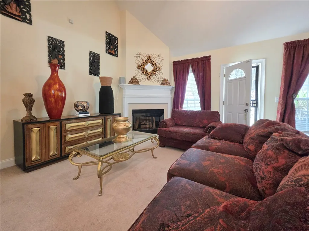 A vaulted ceiling and a wood-burning fireplace anchors this comfortable living area.