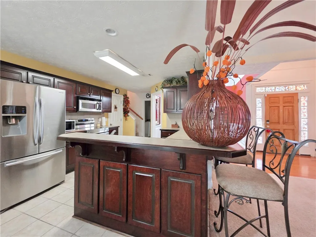 Rich dark wood cabinetry paired with tiled flooring defines this functional cooking and dining space.