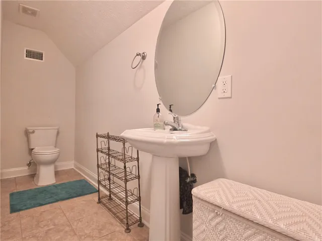 Sloped ceilings and neutral tile flooring define this functional powder room setup.