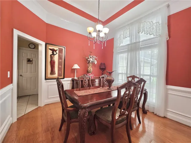 Gleaming hardwood floors and classic wainscoting define this elegant formal dining area.