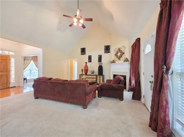 Vaulted ceilings soar over this comfortable living area anchored by a classic fireplace.