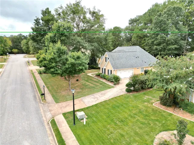 Mature trees surround this quiet corner lot property featuring a spacious concrete driveway.