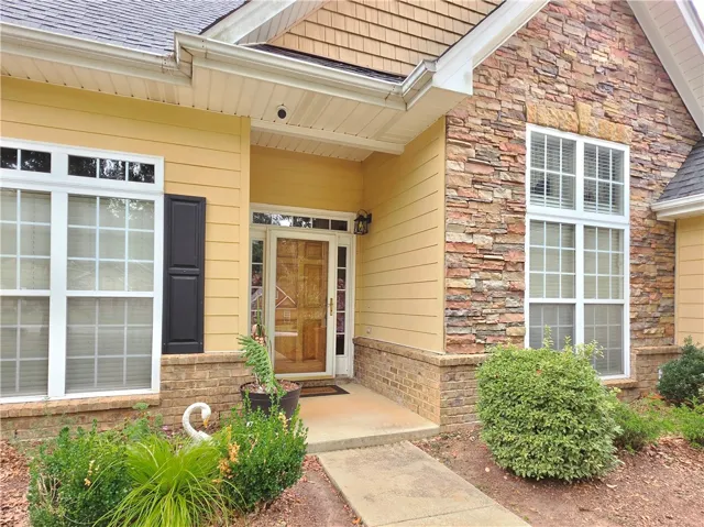 A welcoming front entry features textured stone accents and a classic wooden door.