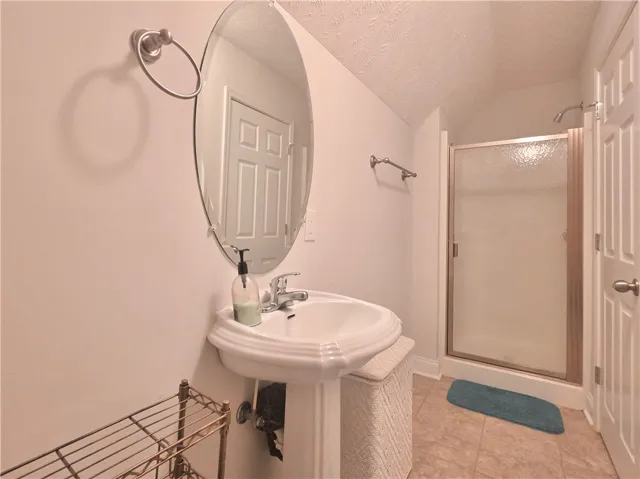 A classic pedestal sink paired with a glass-enclosed shower highlights this functional bathroom space.
