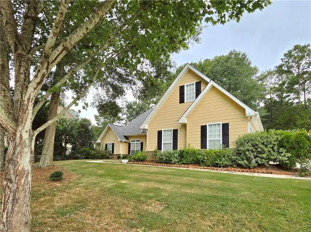 Mature trees shade the gently sloping green lawn of this classic multi-level residence.