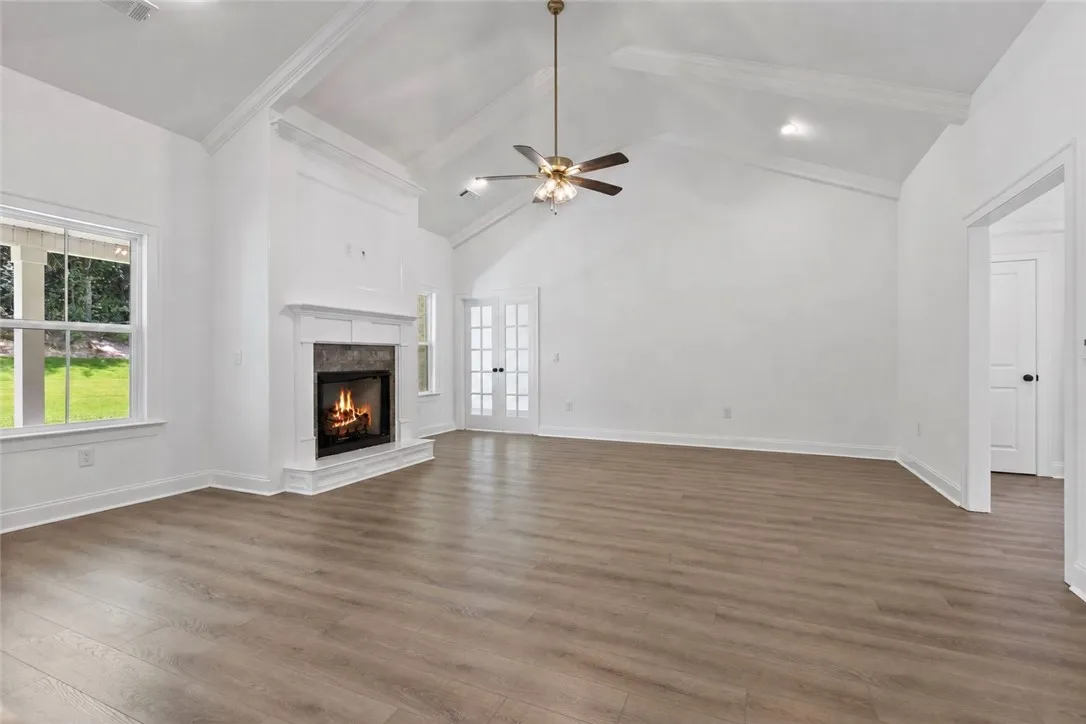 The living room features tall ceilings, recessed lighting, and a gas fireplace with an office just beyond it.