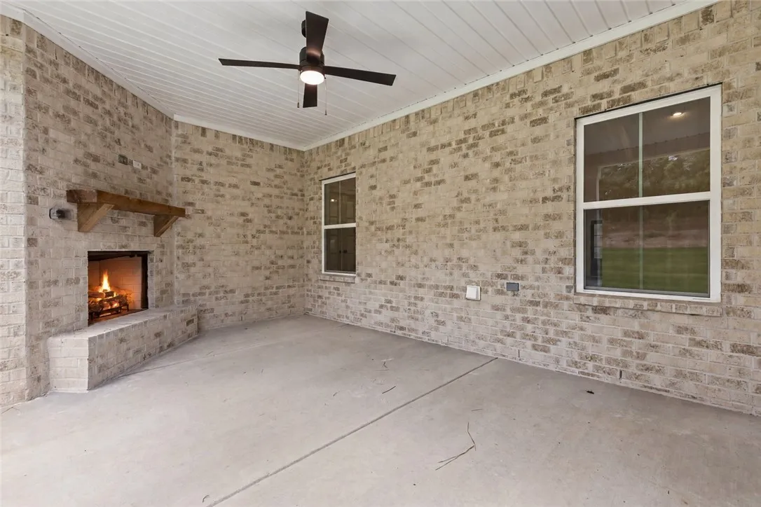 An inviting outdoor fireplace highlights this covered back porch. Gameday ready.