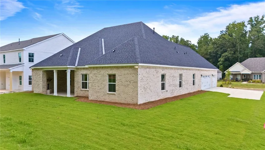 Behind the house is a large backyard with woods behind it.