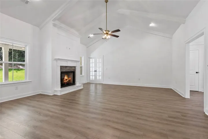 The living room features tall ceilings, recessed lighting, and a gas fireplace with an office just beyond it.