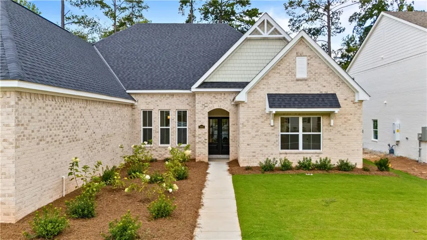 Walkway to the home is enhanced by professional landscaping and the double door entryway,