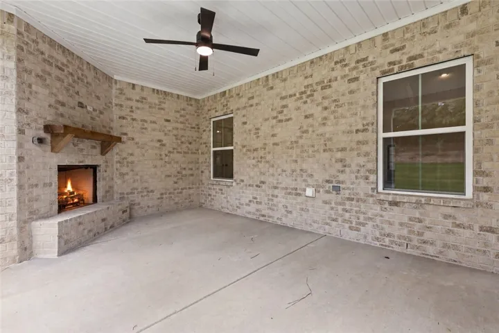 An inviting outdoor fireplace highlights this covered back porch. Gameday ready.
