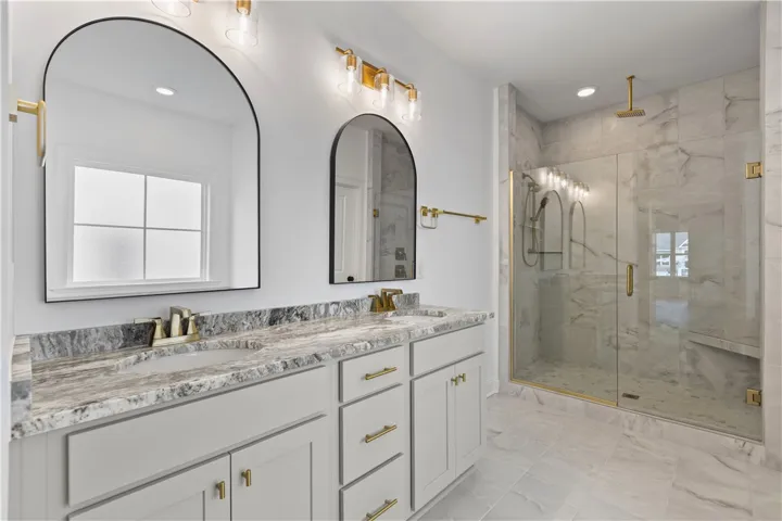 The primary bath has double vanities, a large enclosed shower with two shower heads and a soaker tub.
