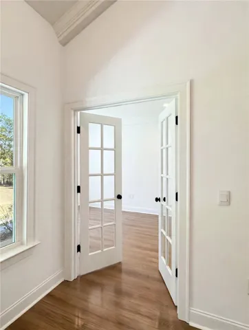 Double glass doors open to reveal a light-filled room with classic crown molding.