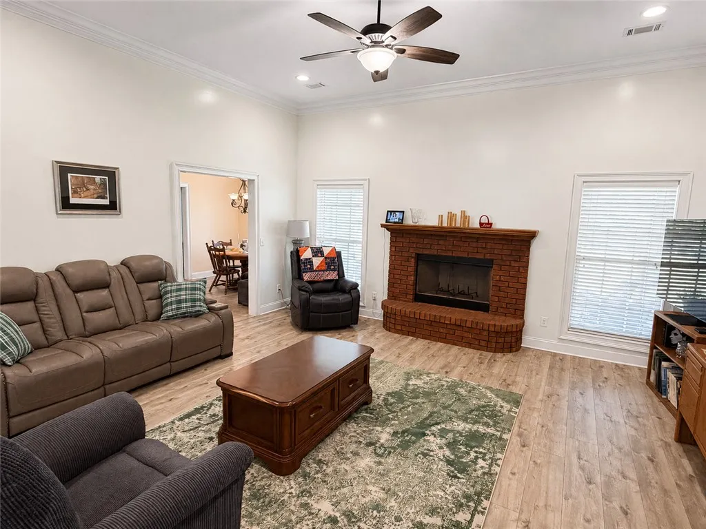 Gleaming wood floors and a classic brick fireplace anchor this welcoming living area.