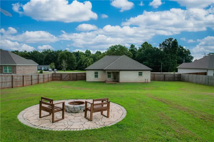 Spacious fenced backyard with firepit area
