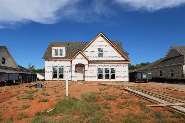 Gabled rooflines and tall windows define this new home currently under construction.